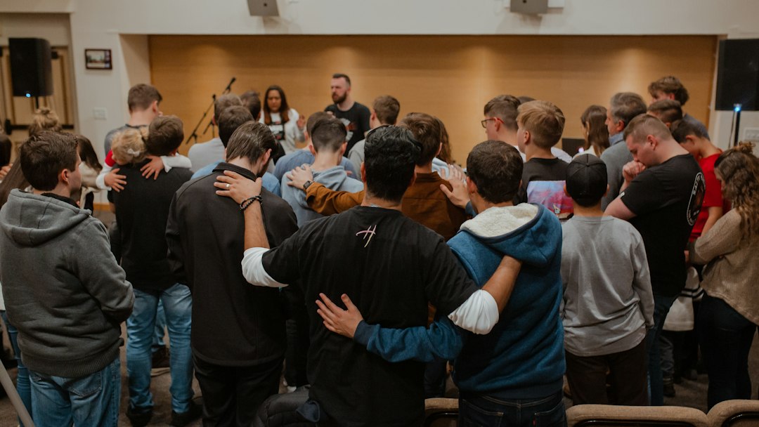 A church small group standing together with arms around each other